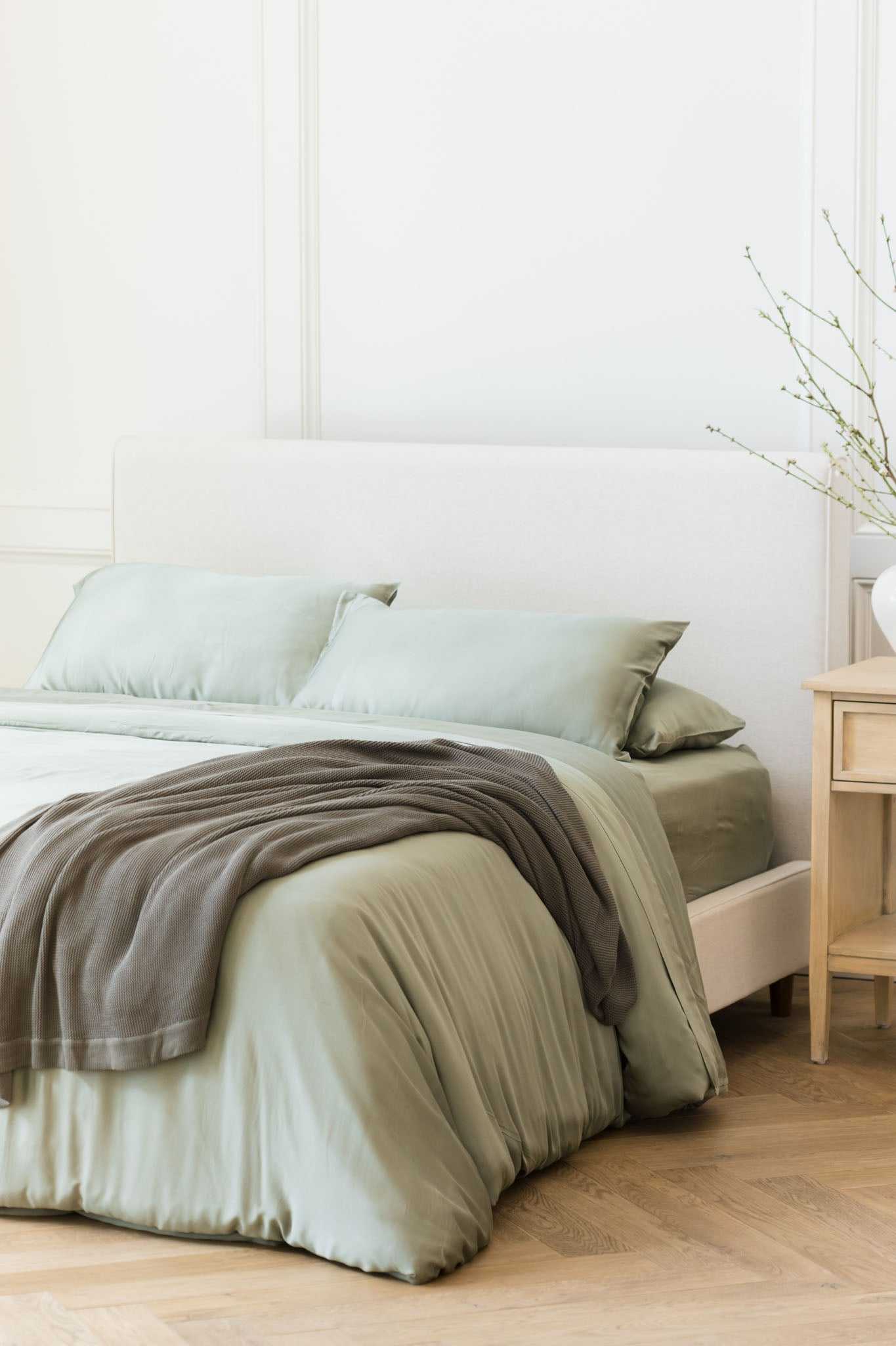 Charcoal cloud knit blanket draped over bed with sage bedding |Color:Charcoal