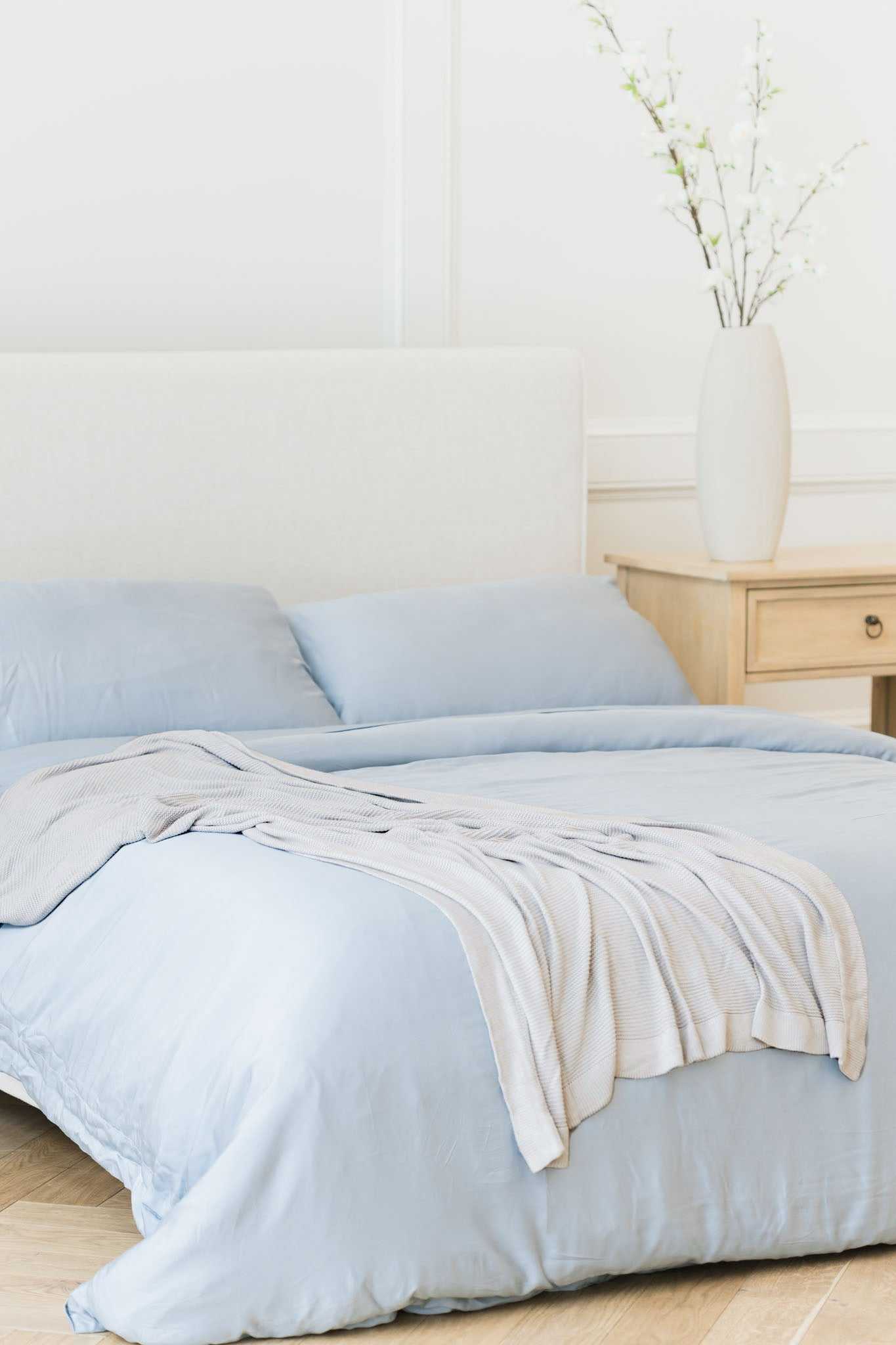 Light Grey cloud knit blanket draped over bed with harbor mist bedding |Color:Light Grey