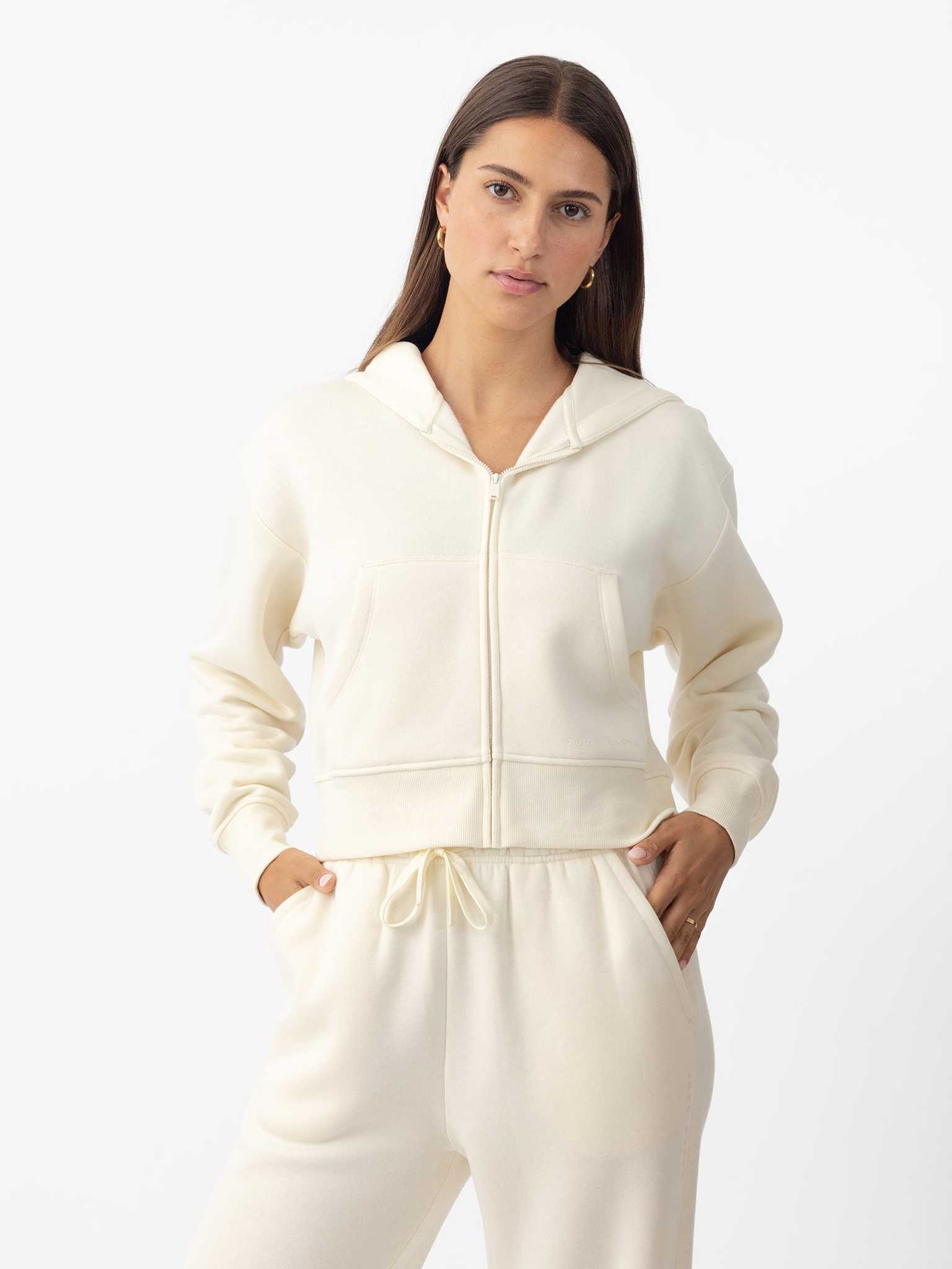 Woman wearing Alabaster CityScape Cropped Full Zip with white background |Color: Alabaster