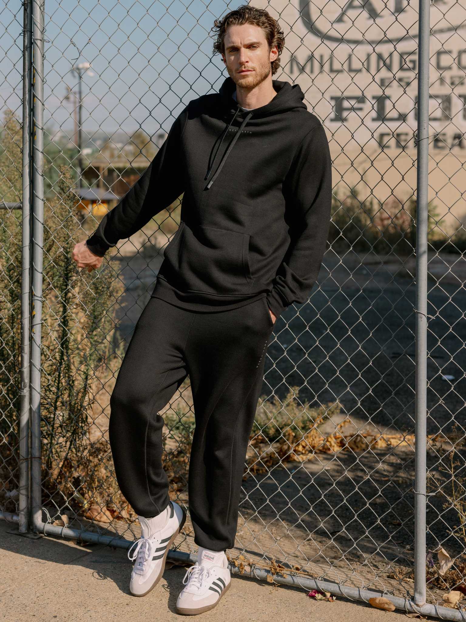 Man next to fence wearing black cityscape sweats and hoodie |Color:Black