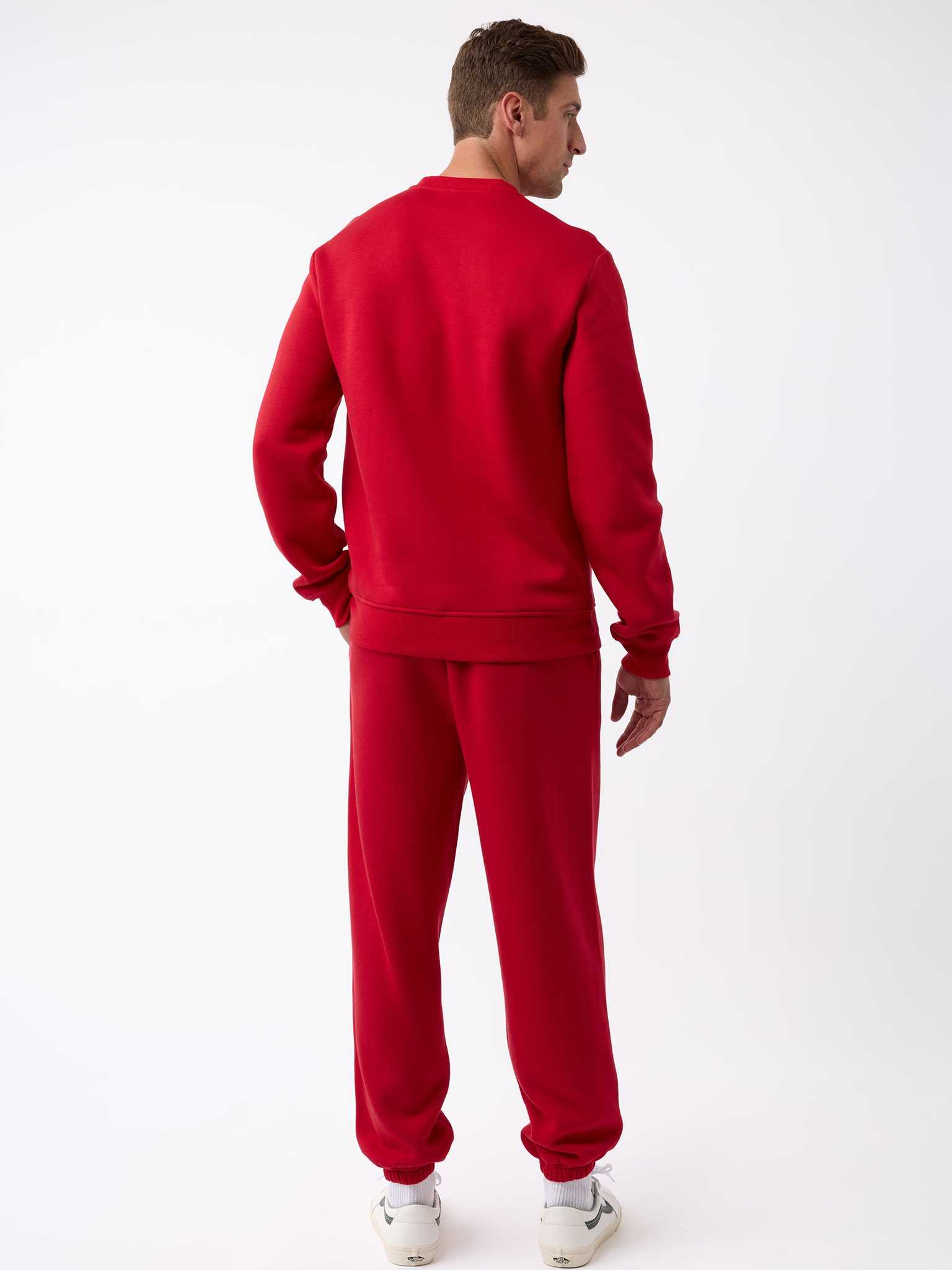 A person stands facing away, donning a matching red Men's CityScape Crewneck from Cozy Earth paired with white sneakers. The plain white background accentuates the vibrant color of the outfit. |Color:Crimson