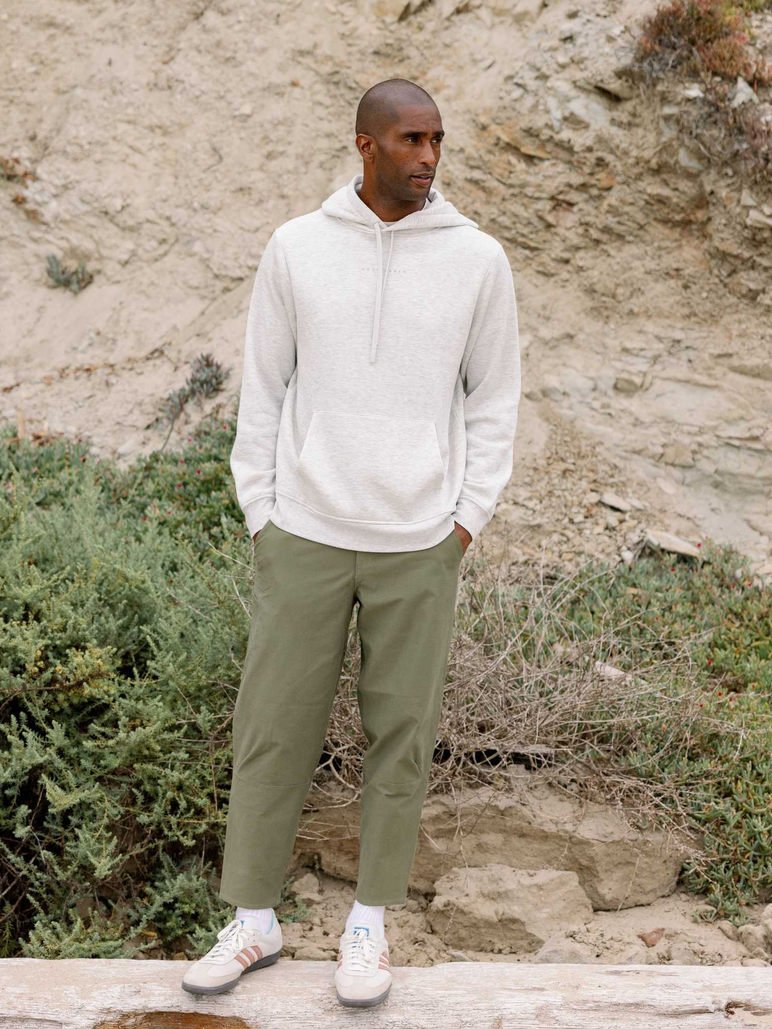 Man wearing heather grey cityscape hoodie with rocky backdrop |Color:Heather Grey