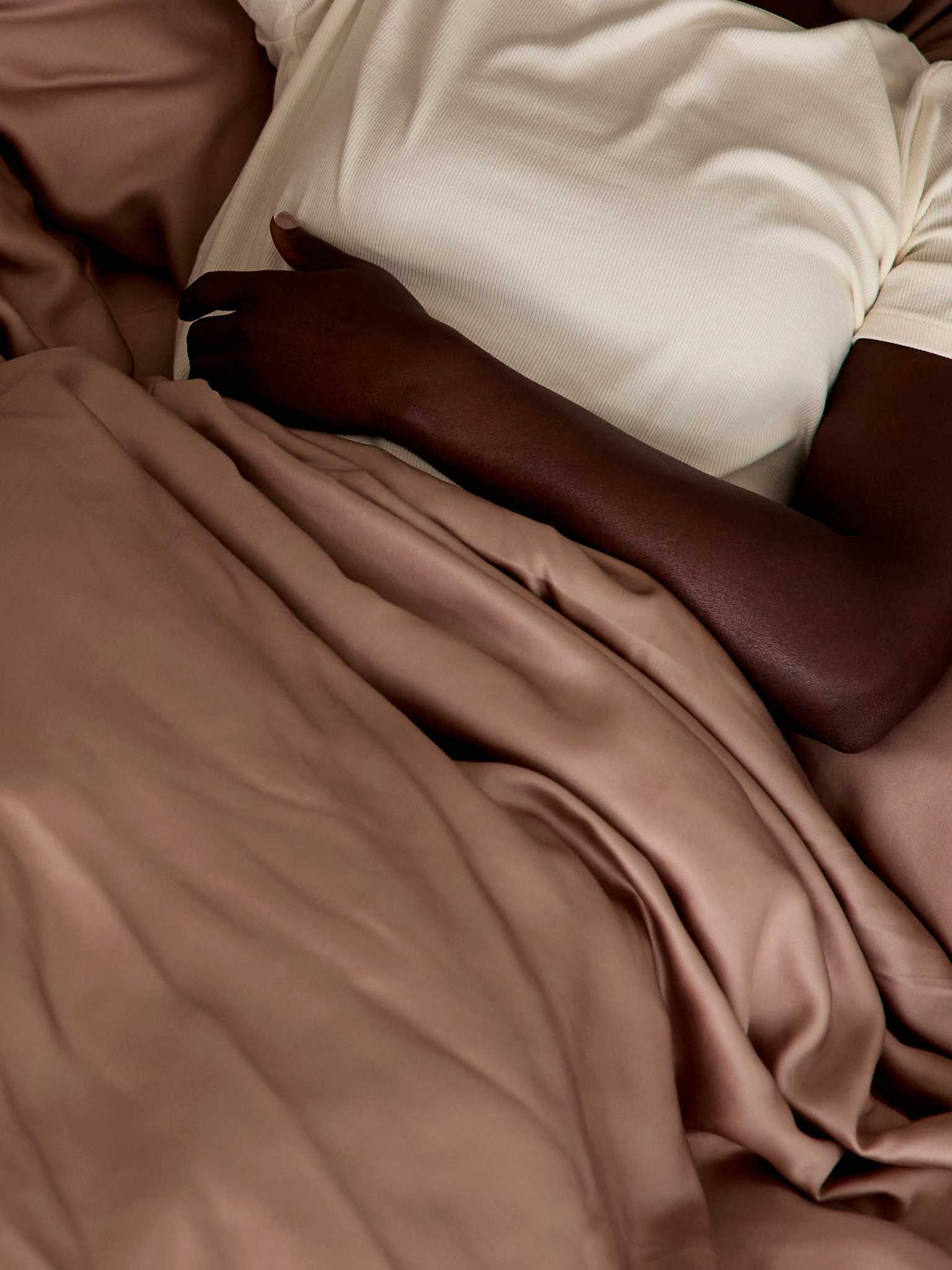 Close up of woman laying in bed with clay sheets |Color:Clay