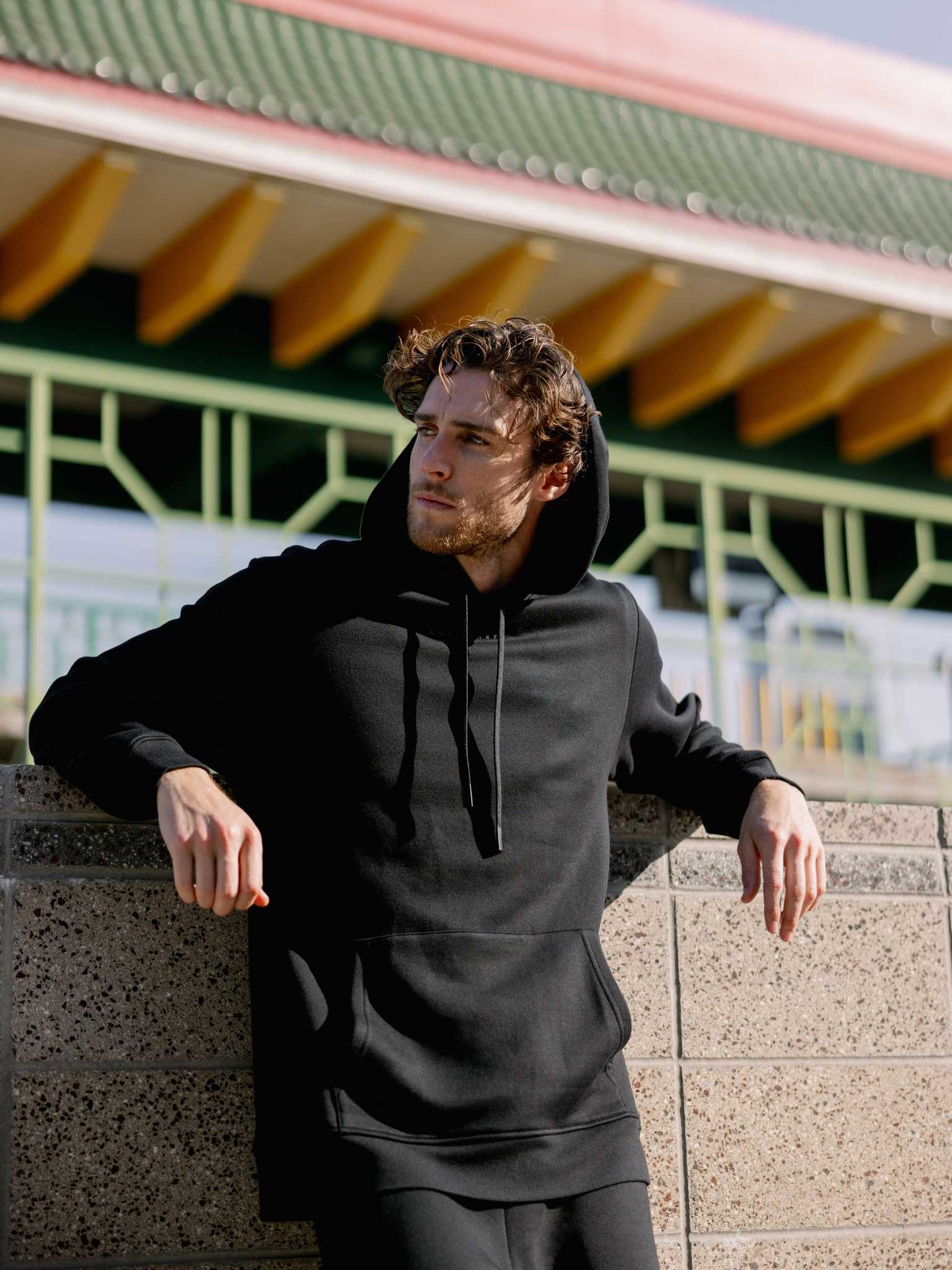 Man leaning against city wall wearing black cityscape hoodie |Color:Black