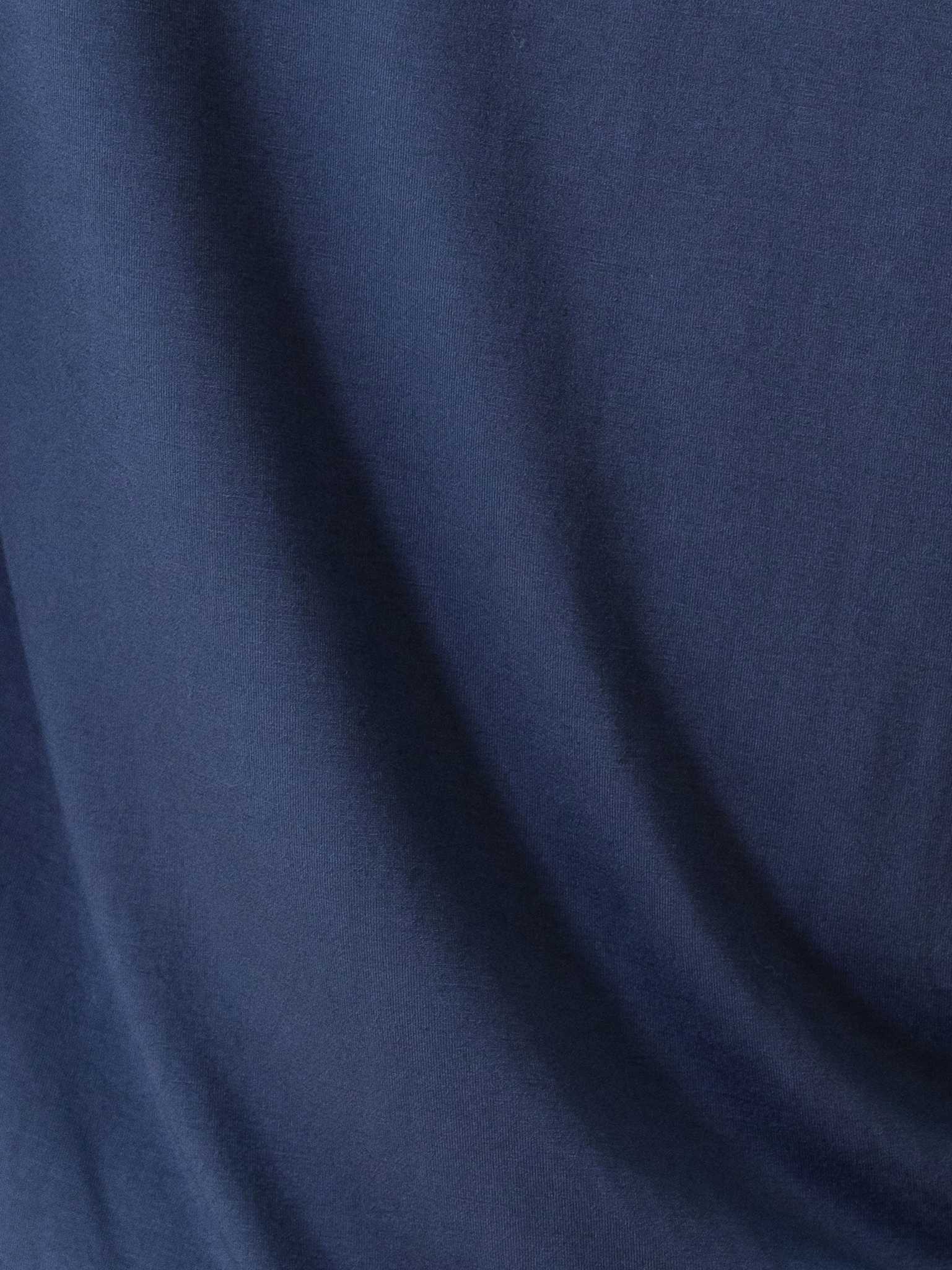 A close-up view of the dark blue fabric from the Women's Bedtime Bundle by Cozy Earth, showcasing its smooth texture and soft draping. |Color:Navy