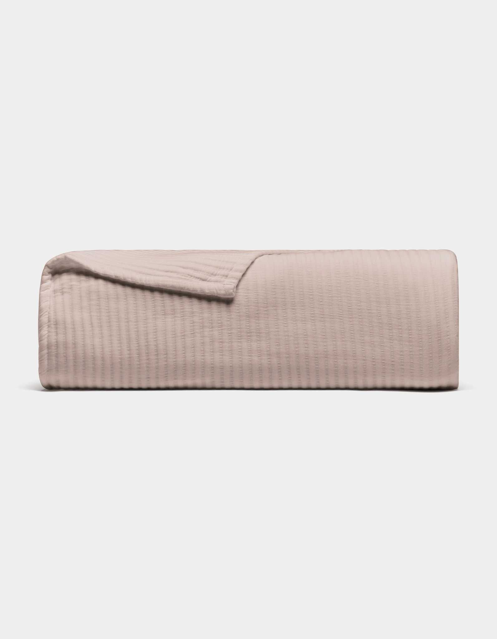 The Cozy Earth Bamboo Coverlet, shown folded in light beige with a subtle stitched texture, is displayed against a plain white background.|Color:Driftwood