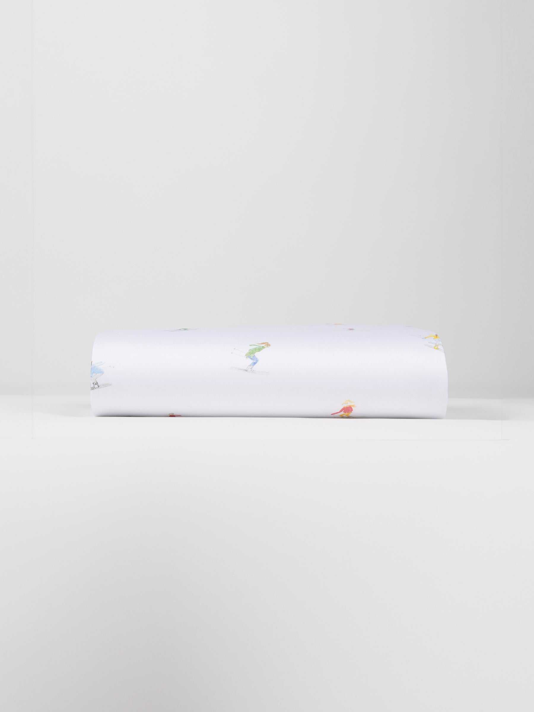 A neatly folded Bamboo Duvet Cover by Cozy Earth, showcasing small, colorful illustrations of people engaged in various activities against a plain white background. |Color:Skiers