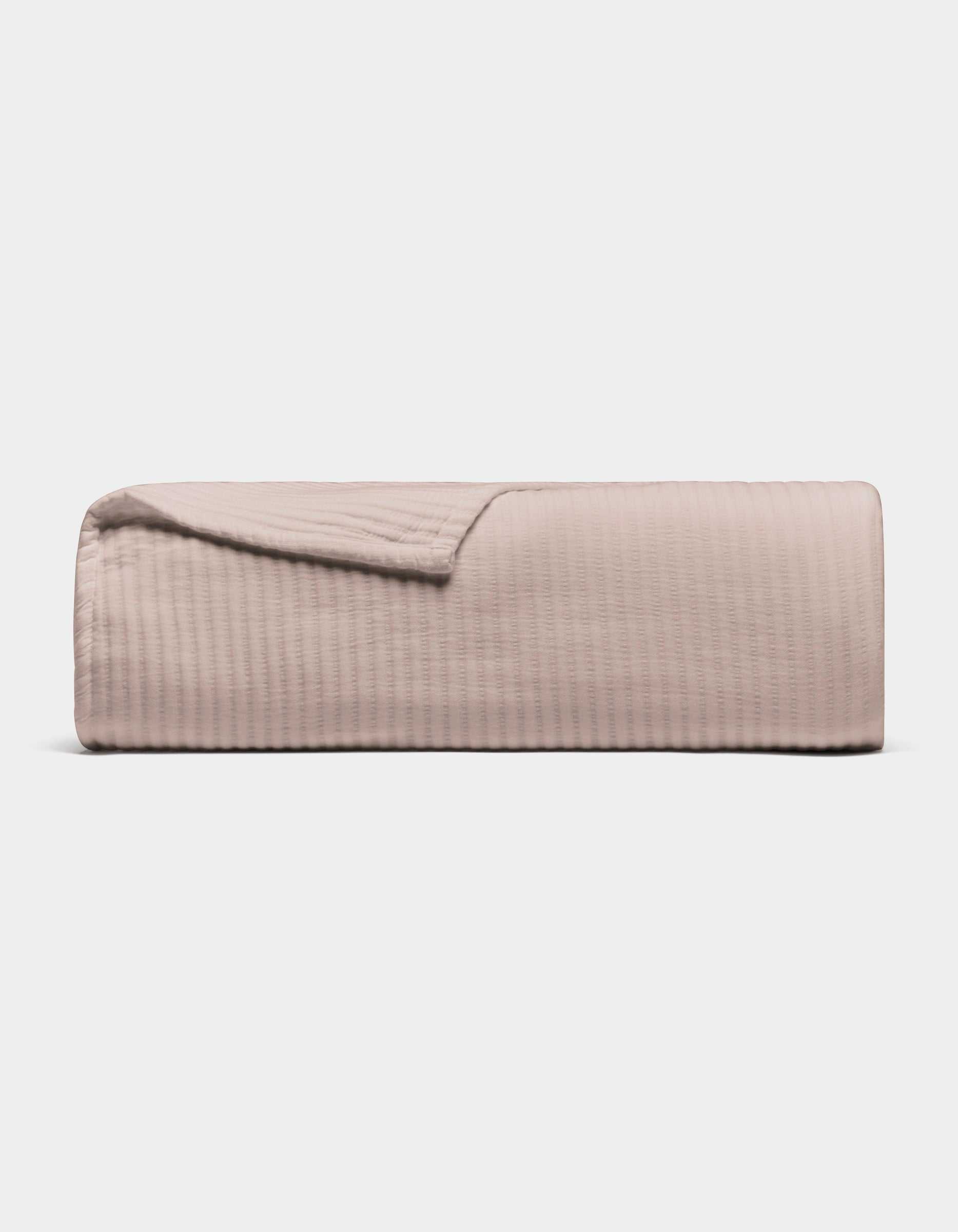The Cozy Earth Bamboo Coverlet, shown folded in light beige with a subtle stitched texture, is displayed against a plain white background.|Color:Driftwood