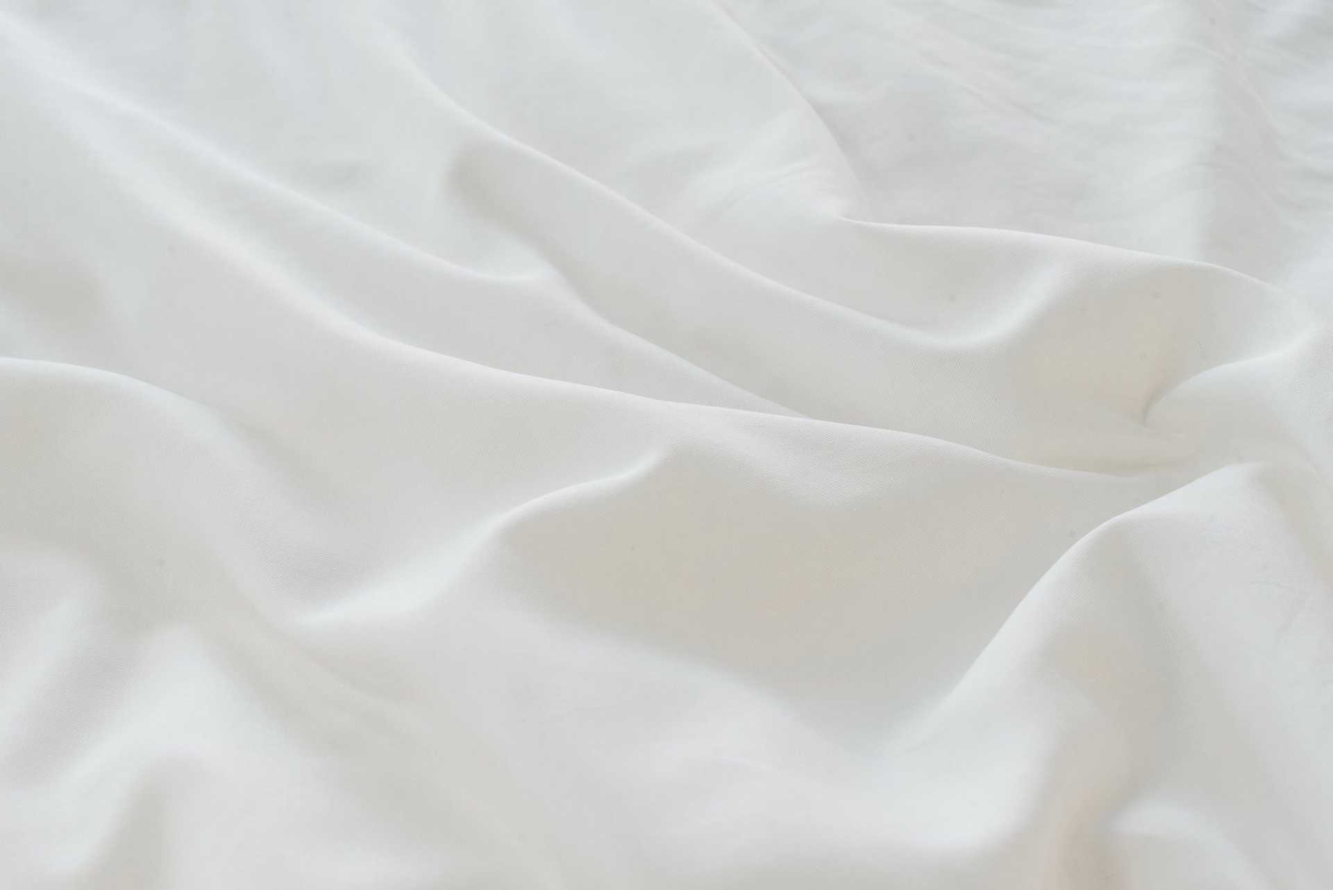 White Linen Bamboo Duvet Cover and comforter resting on a bed. Photo or product taken close up. |Color: White