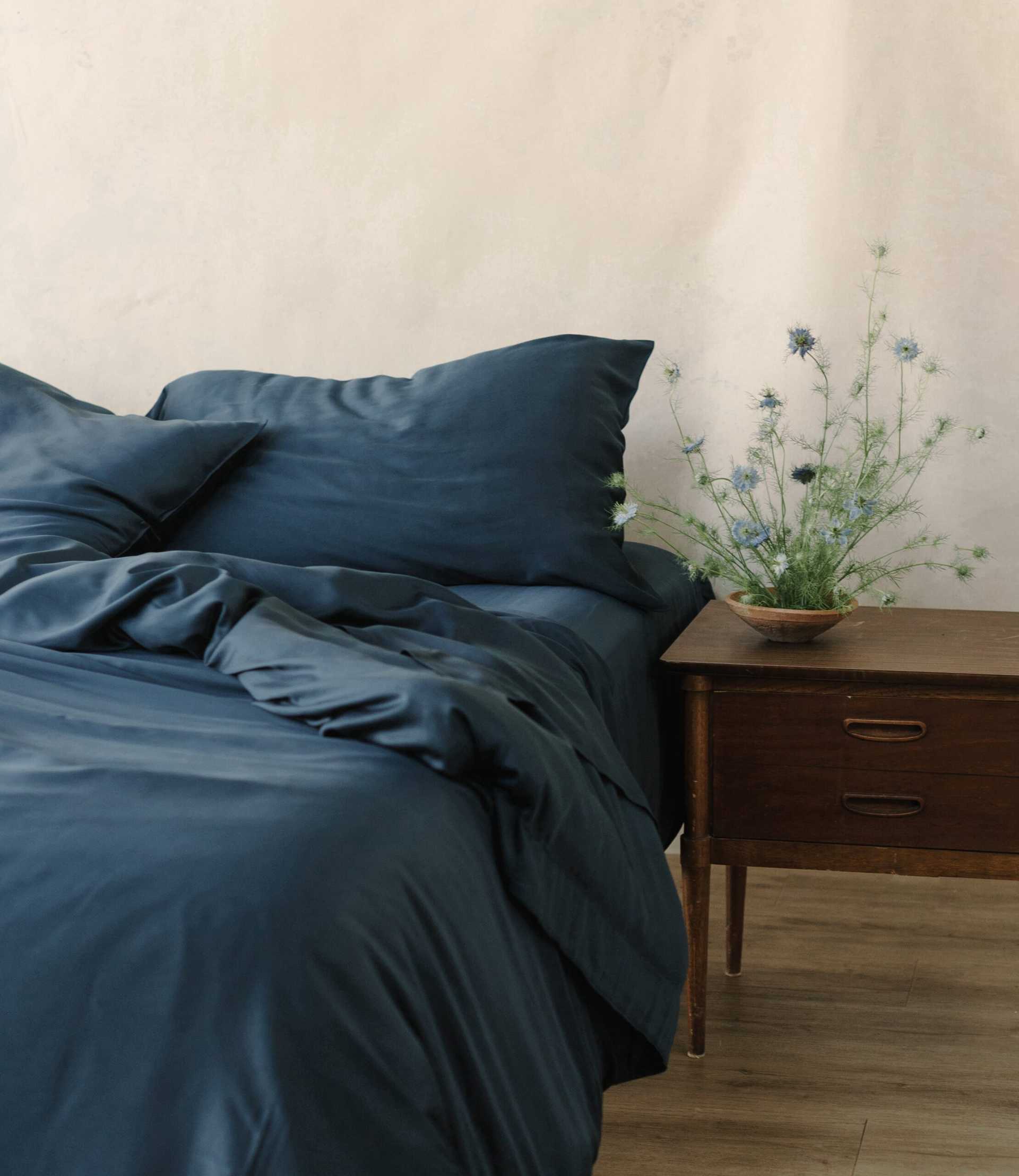 Unmade bed with navy bedding |Color:Navy