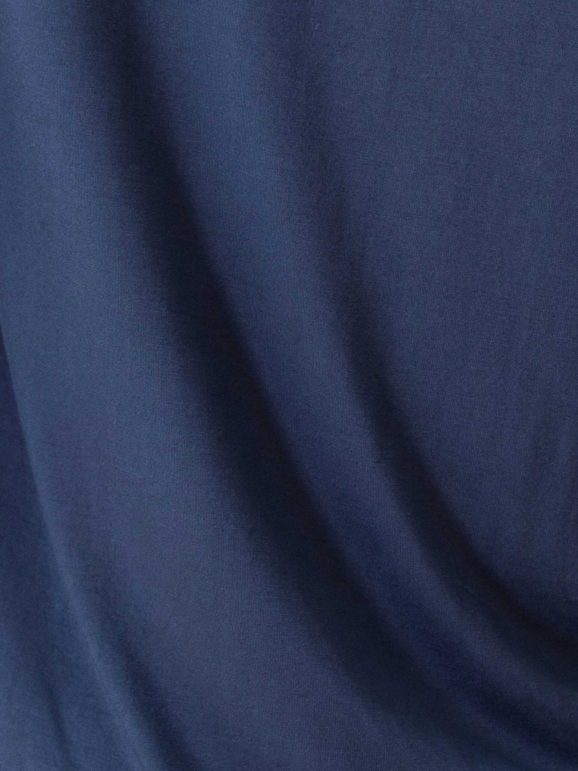 A close-up view of the dark blue fabric from the Women's Bedtime Bundle by Cozy Earth, showcasing its smooth texture and soft draping. |Color:Navy