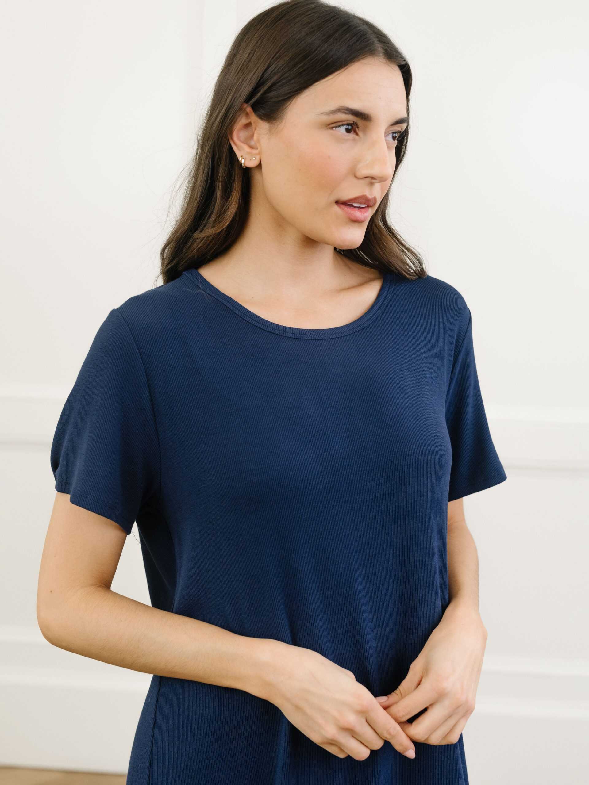 A woman standing in a navy Cozy Earth bamboo rib-knit boyfriend sleep dress with short sleeves, in front of a grey background. |Color:Navy