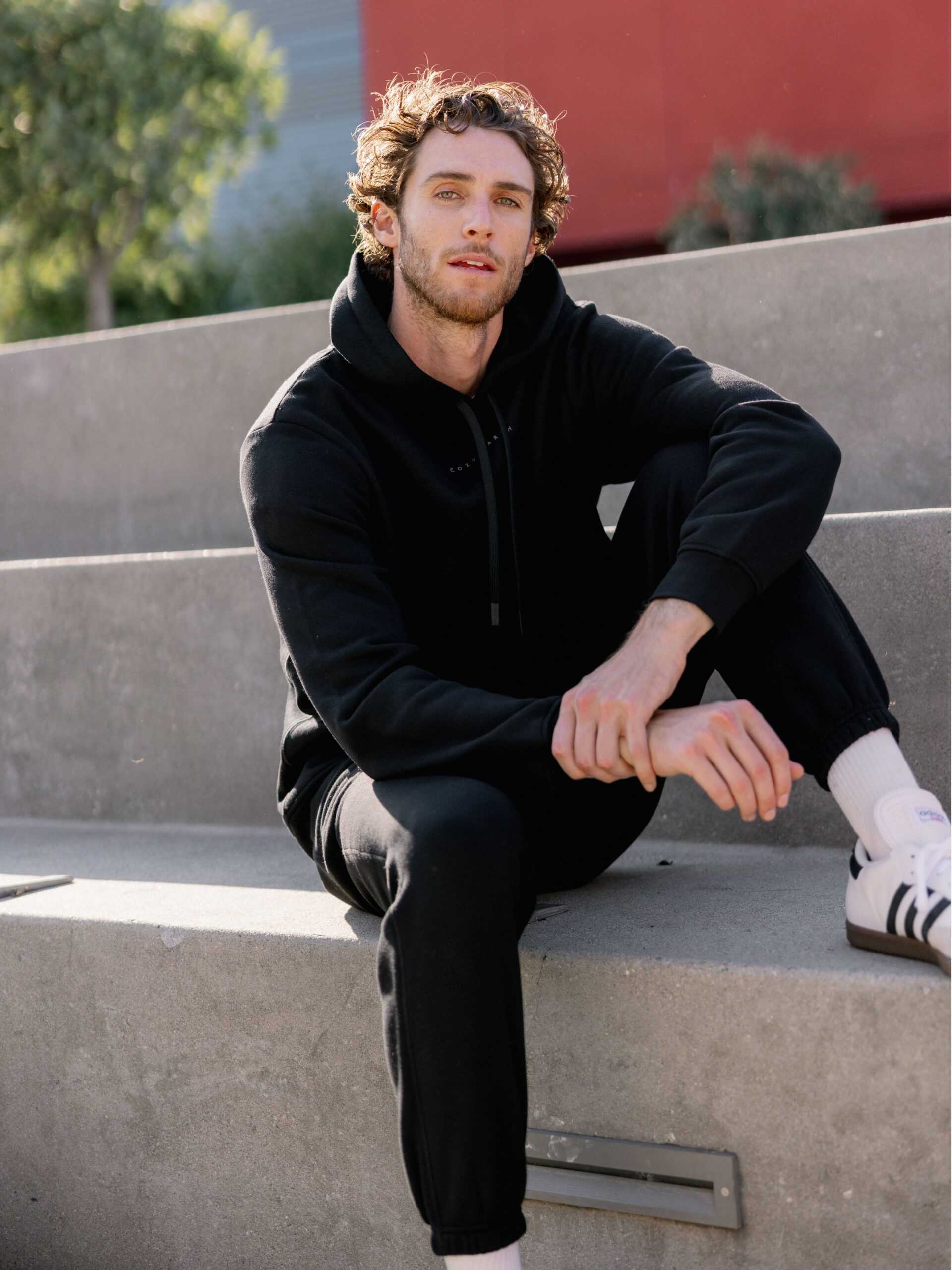 Man sitting outside in black cityscape hoodie and sweats |Color:Black