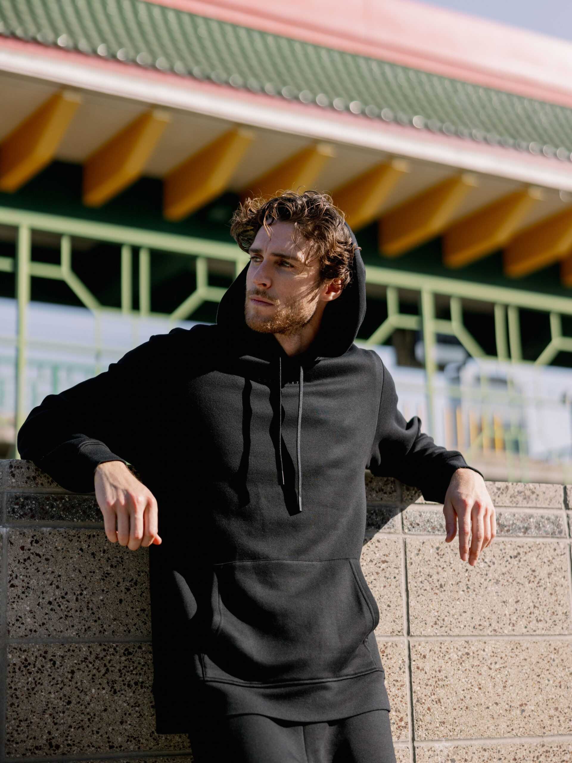 Man leaning against city wall wearing black cityscape hoodie |Color:Black