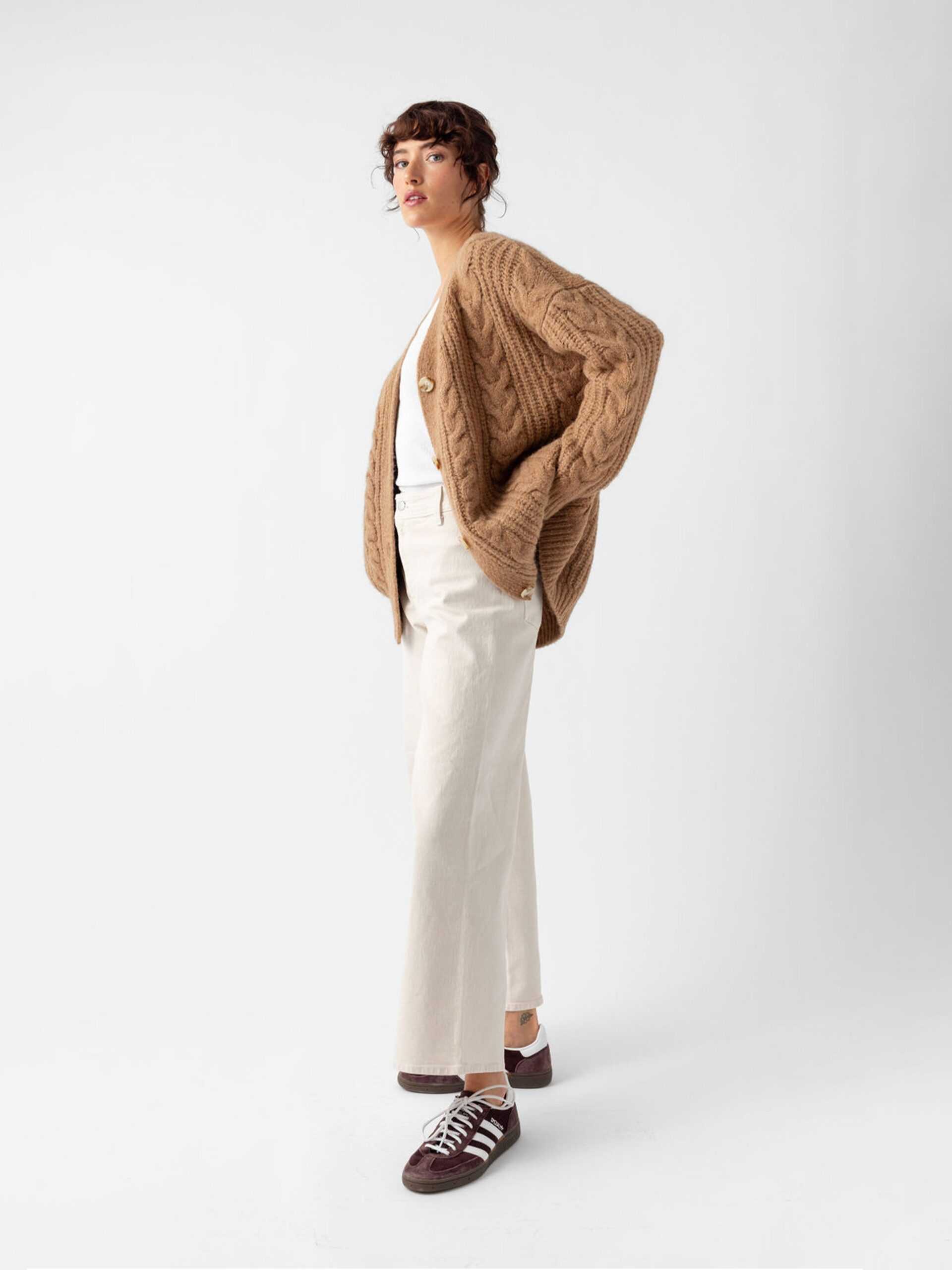 Side view of woman wearing camel cardigan and off-white pants with white background |Color:Camel