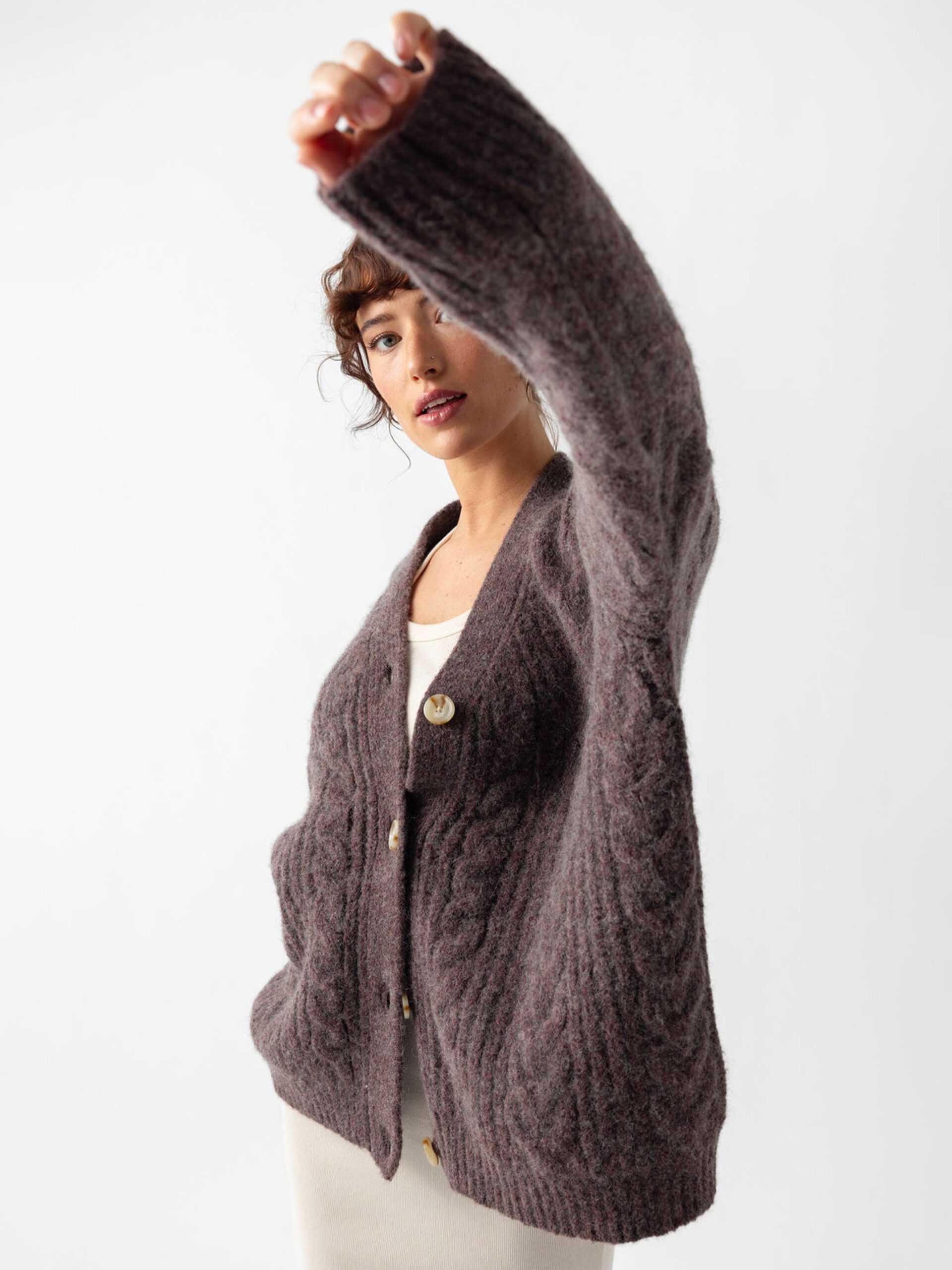 Studio image of woman wearing bordeaux cardigan holding her left arm toward the camera |Color:Bordeaux