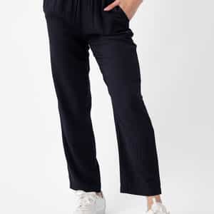Person wearing Cozy Earth's Women's Sunset Cropped Pant in Jet Black with hands in pockets and white sneakers. The background is plain white. |Color:Jet Black