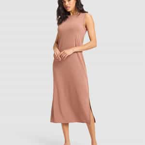 A woman models the Cozy Earth Women's Brushed Bamboo Sleeveless Midi Dress in light brown, paired with black slide sandals featuring gold accents, posing against a plain light gray background. |Color:Saddle