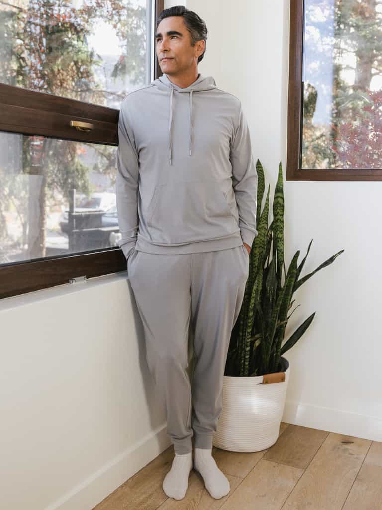 Stone Bamboo Hoodie and Jogger set worn by man standing in front of a window.|Color:Stone