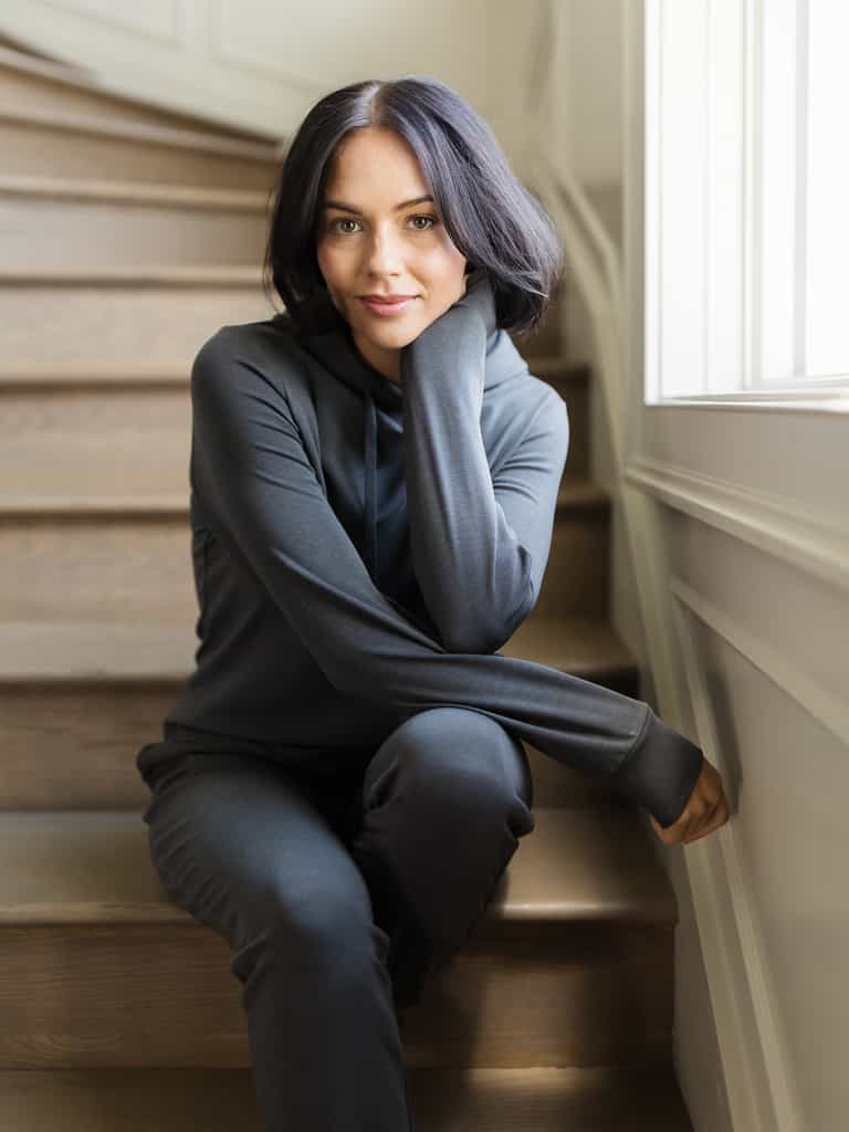 Charcoal Bamboo Jogger Set modeled by a woman. The photo was taken in a high contrast setting, showing off the colors and lines of the pajamas. |Color: Charcoal