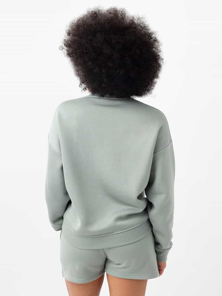 Haze CityScape Pullover Crew. The Pullover is being worn by a female model. Accompanying city scape clothing is being worn to complete the look of the outfit. The photo was taken with a white background. |Color:Haze