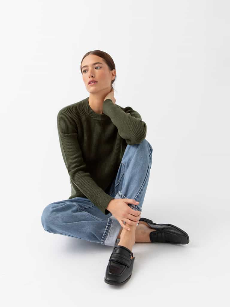 Woman sitting wearing juniper classic crewneck and jeans with white background |Color:Juniper