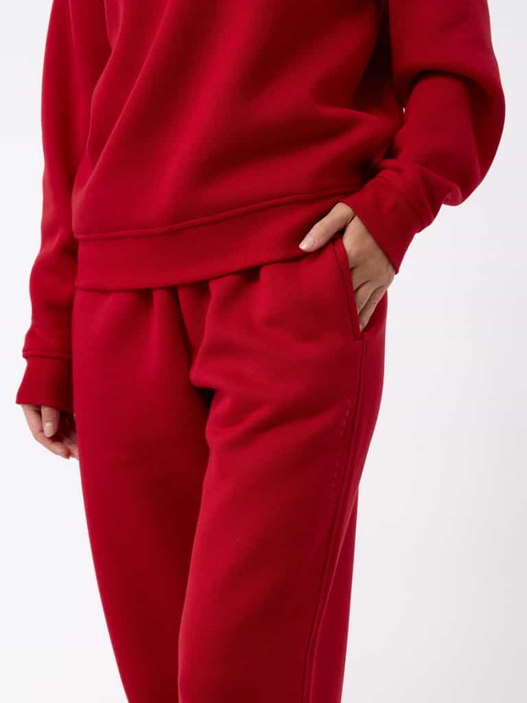 A person is wearing the Women's CityScape Wide Leg Pant by Cozy Earth in a striking red color, with one hand tucked into the pocket. The fabric looks incredibly soft and comfortable, and the outfit is showcased against a simple white background. |Color:Crimson