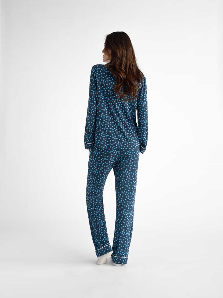 A person with long brown hair is shown from behind on a plain white background, wearing the Cozy Earth Women's Bamboo Stretch-Knit Pajama Pant in blue with white polka dots. |Color:Forget Me Nots