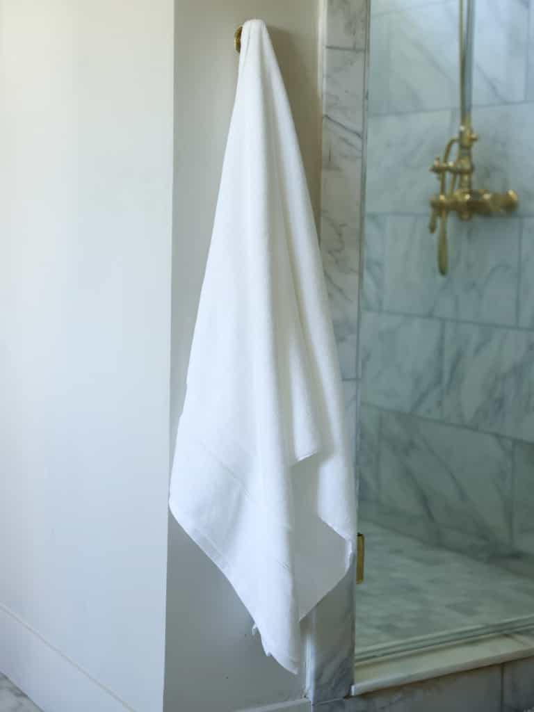 White luxe bath towel hanging next to shower |Color:White