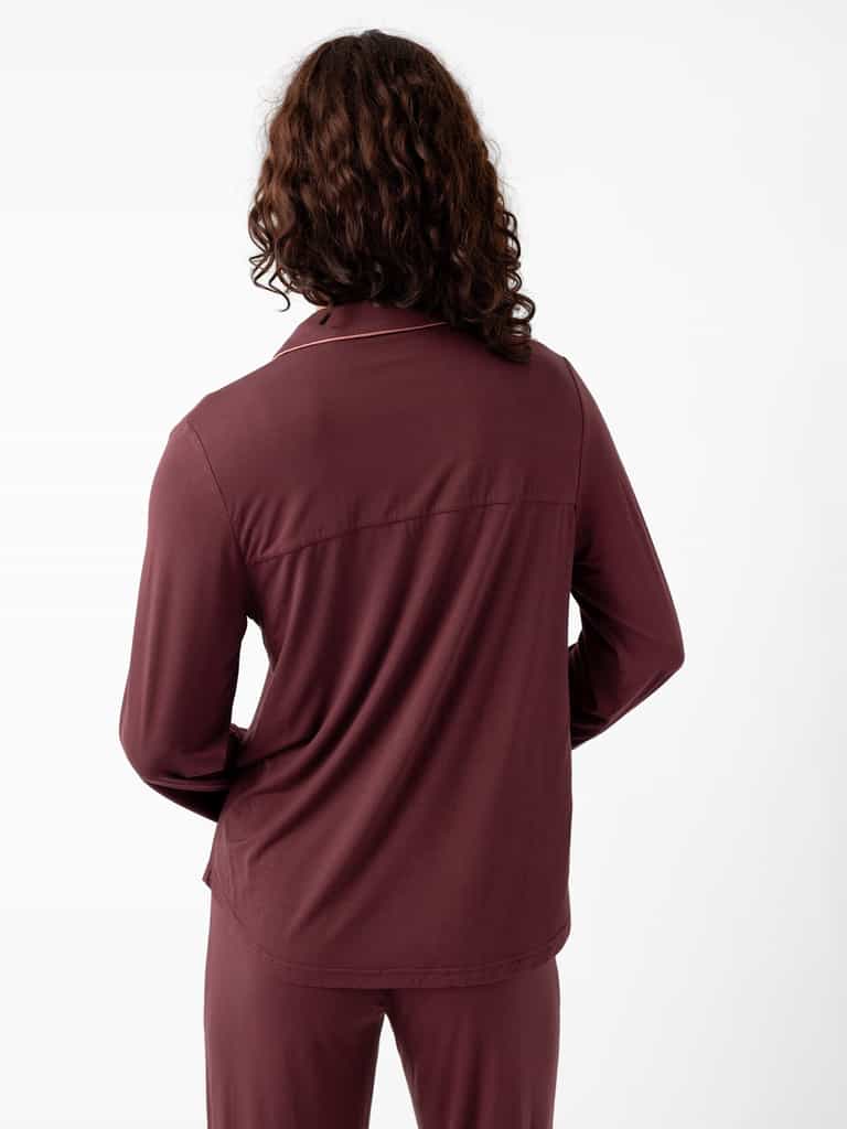 A person with long curly hair models a Cozy Earth Women's Bamboo Stretch-Knit Pajama Set in burgundy, shown from behind against a white background. |Color:Burgundy