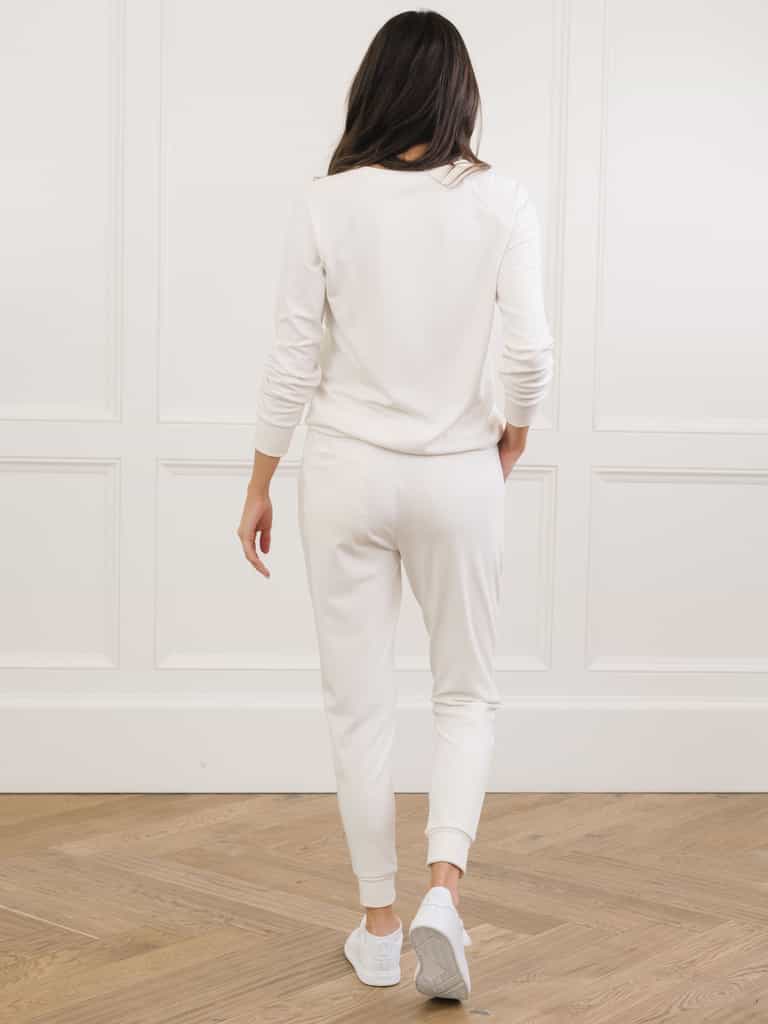 Ivory Bamboo Jogger Set modeled by a woman. The photo was taken in a high contrast setting, showing off the colors and lines of the pajamas. |Color: Ivory