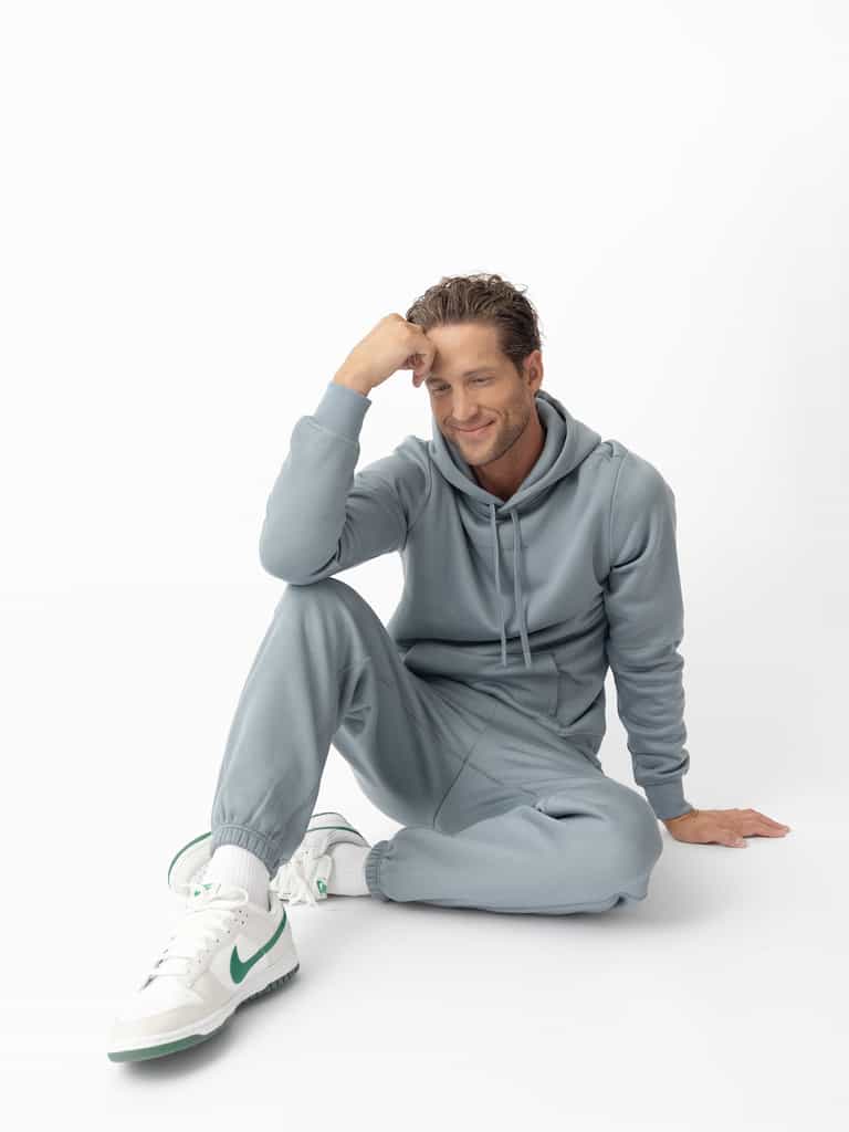 Man sitting on ground wearing smokey blue cityscape hoodie and sweats |Color:Smokey Blue