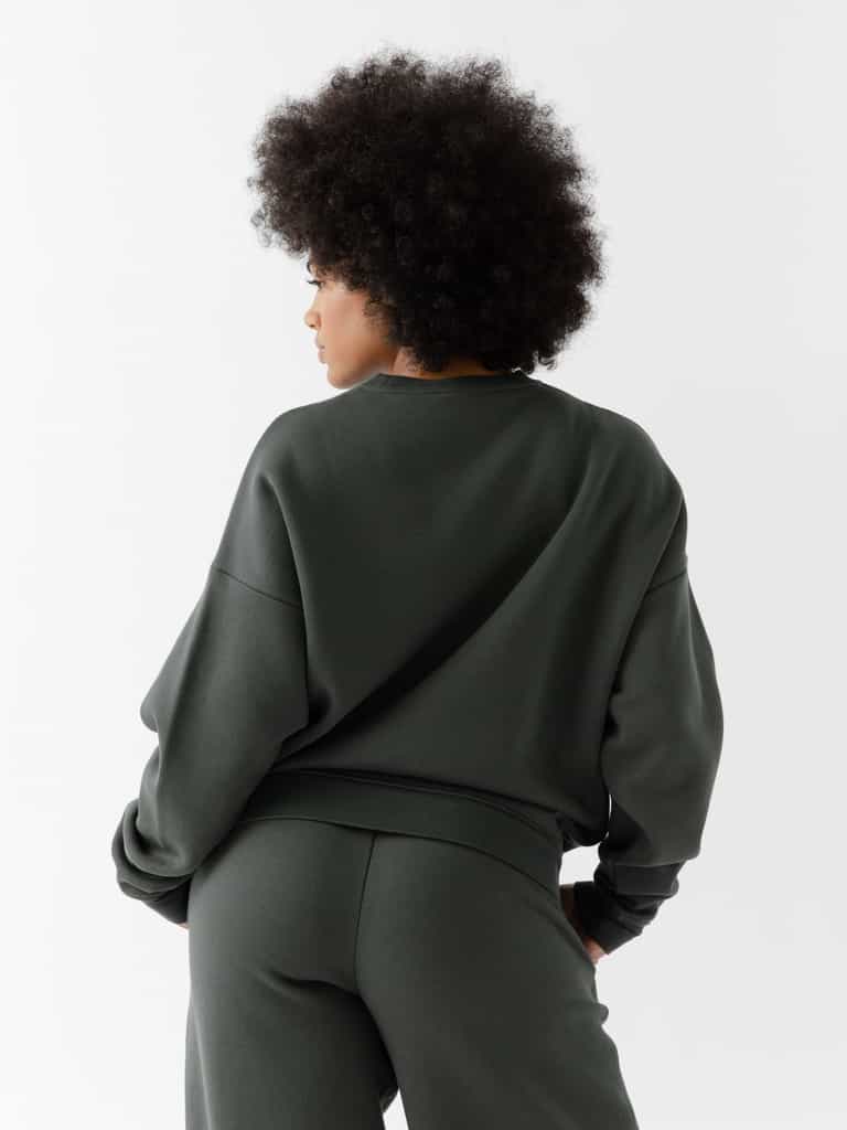 Storm CityScape Pullover Crew. The Pullover is being worn by a female model. Accompanying city scape clothing is being worn to complete the look of the outfit. The photo was taken with a white background. |Color:Storm