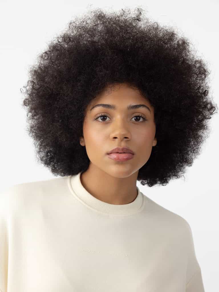 Woman wearing Alabaster CityScape Crewneck with white background |Color: Alabaster