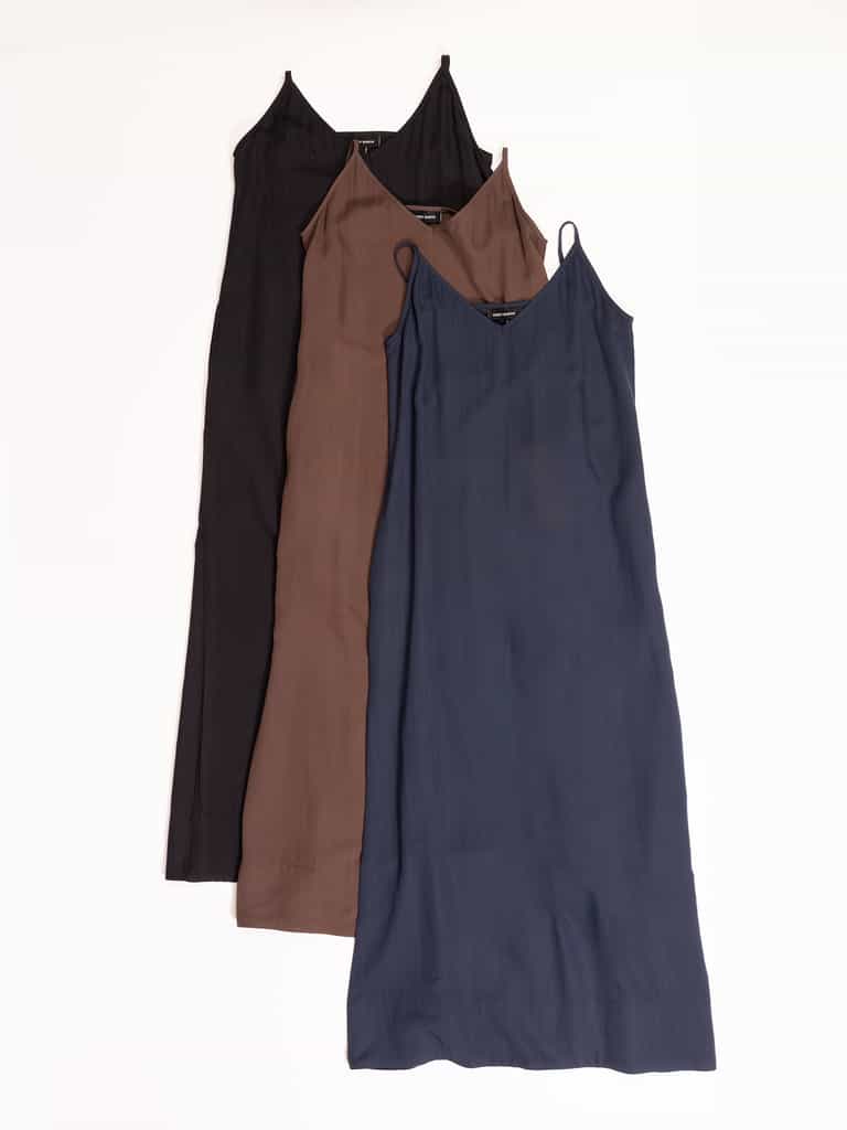 Three Cozy Earth Women's Sunset Slip Dresses are laid flat, aligned vertically. From top to bottom, the dresses are black, brown, and dark blue. They feature thin straps and a simple, elegant design. The image background is a clean, plain white. |Color:Eclipse
