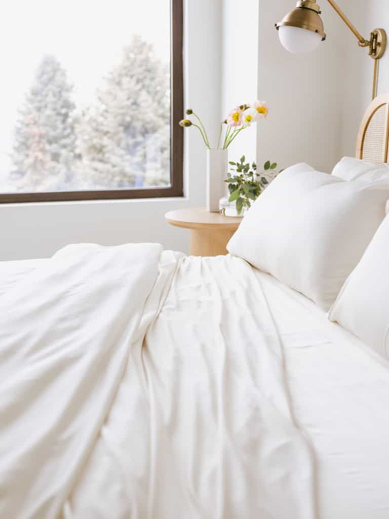 Creme bedding on an unmade bed with trees out the window |Color:Creme