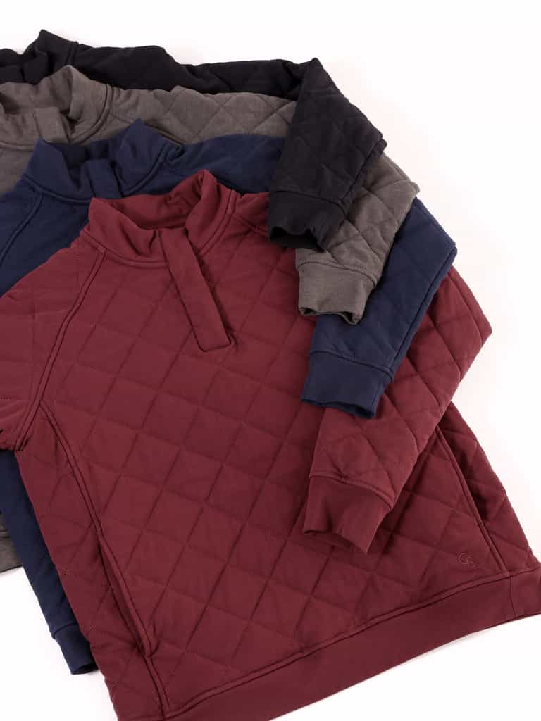 Flat lay of quilted snap pullover in black, charcoal, navy, and burgundy.