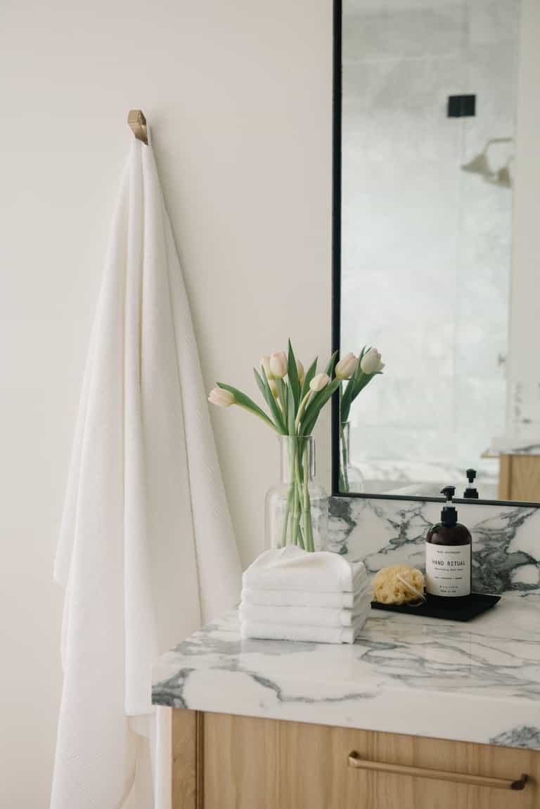 Ribbed Terry Bath Sheets in the color White. Photo of product taken in a bathroom next to a sink. |Color:White