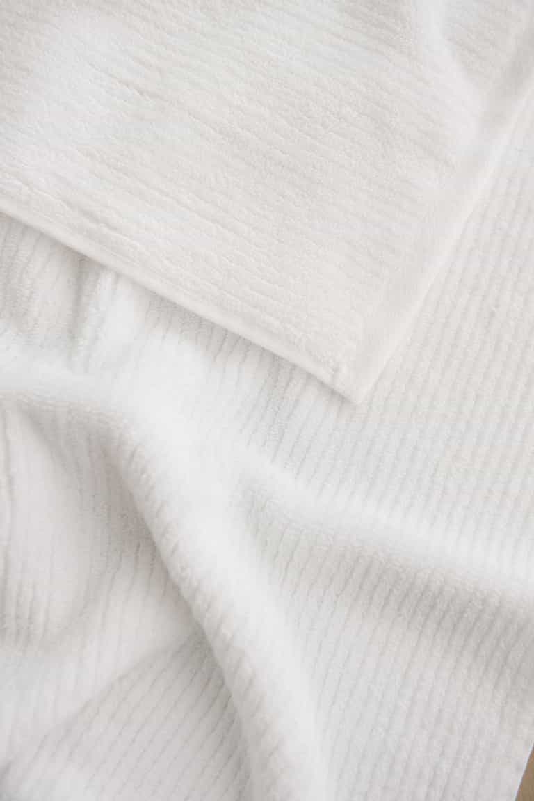 Ribbed Terry Hand Towel in the color White. Photo of Ribbed Terry Hand Towel taken as a close up of the towel. Only the towel is seen. |Color: White