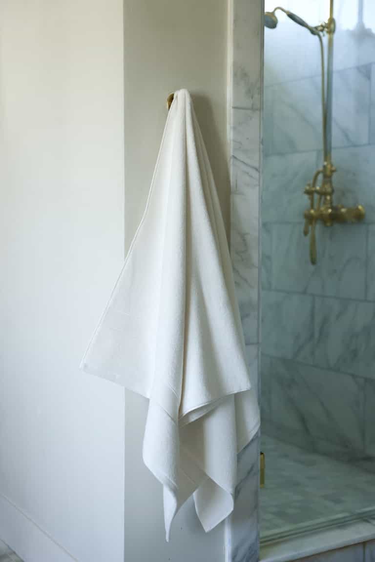 Seashell luxe bath towel hanging next to shower |Color:Seashell
