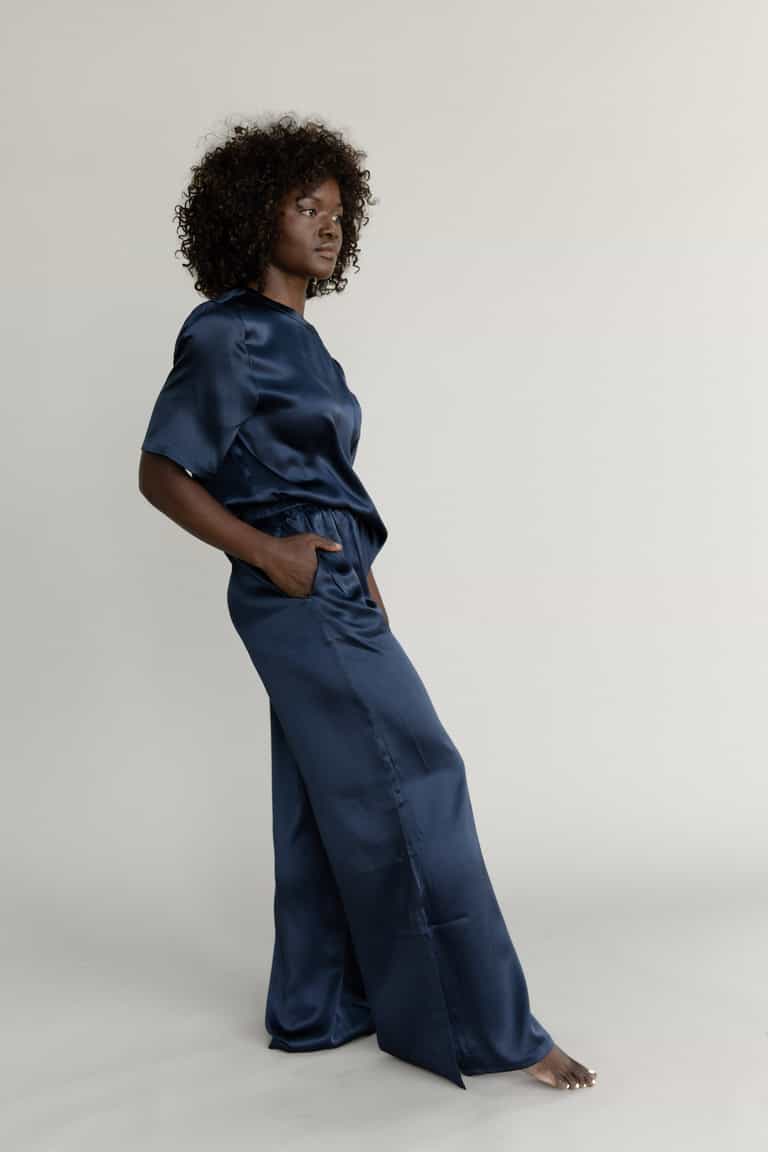 Navy Serenity Silk Scoop Neck Tee modeled by a woman. The photo was taken in a high contrast setting, showing off the colors and lines of the tee. |Color: Navy