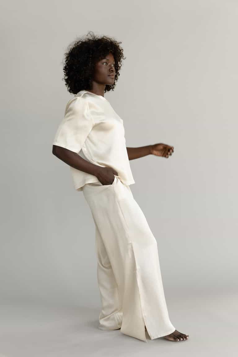 Champagne Serenity Silk Scoop Neck Tee modeled by a woman. The photo was taken in a high contrast setting, showing off the colors and lines of the tee. |Color: Champagne