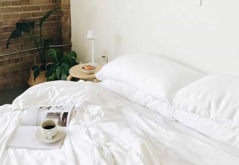 A set of two Cozy Earth Bamboo Pillowcases in white on a bed