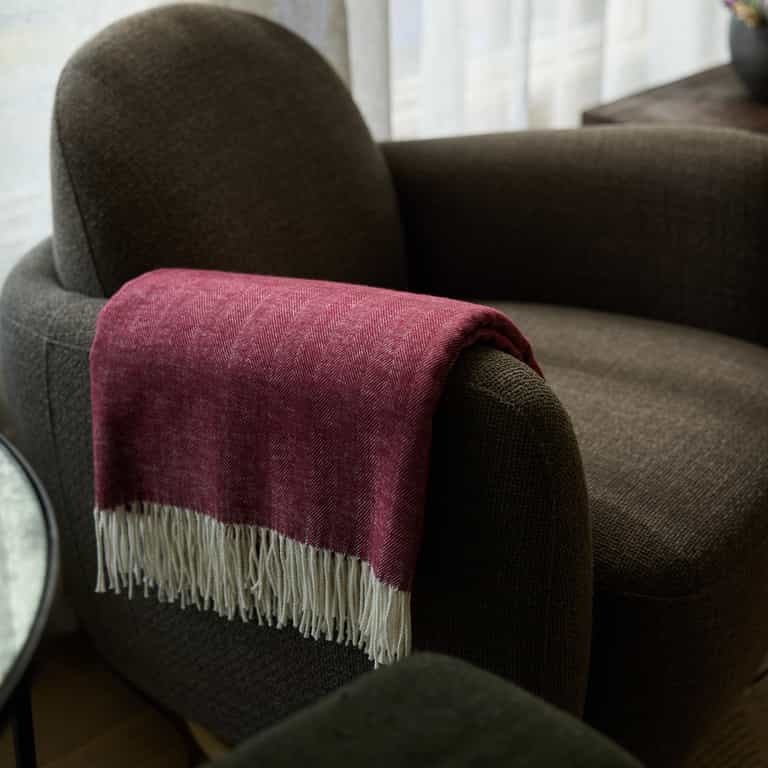 Berry herringbone tassel throw draped over recliner |Color:Berry