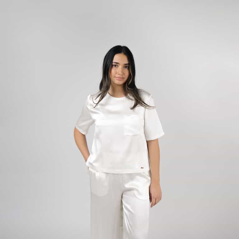 Ivory Serenity Silk Scoop Neck Tee modeled by a woman. The photo was taken in a high contrast setting, showing off the colors and lines of the tee. |Color: Ivory