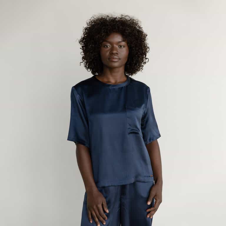 Navy Serenity Silk Scoop Neck Tee modeled by a woman. The photo was taken in a high contrast setting, showing off the colors and lines of the tee. |Color: Navy
