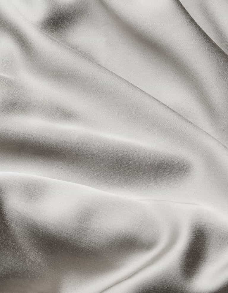 Close-up of Cozy Earth Bamboo Sheet Set featuring smooth, light-colored fabric with gentle folds and a subtle sheen for a soft, elegant texture.|Color:Light Grey