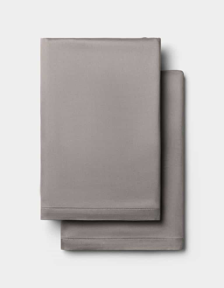 Two light gray Cozy Earth Bamboo Pillowcases, neatly folded and stacked against a plain white background.|Color:Charcoal