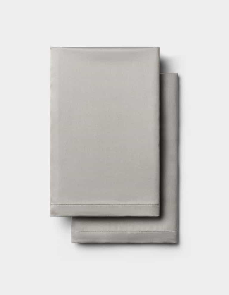 Two neatly folded light gray Cozy Earth Bamboo Pillowcases stacked on a plain white background.|Color:Light Grey