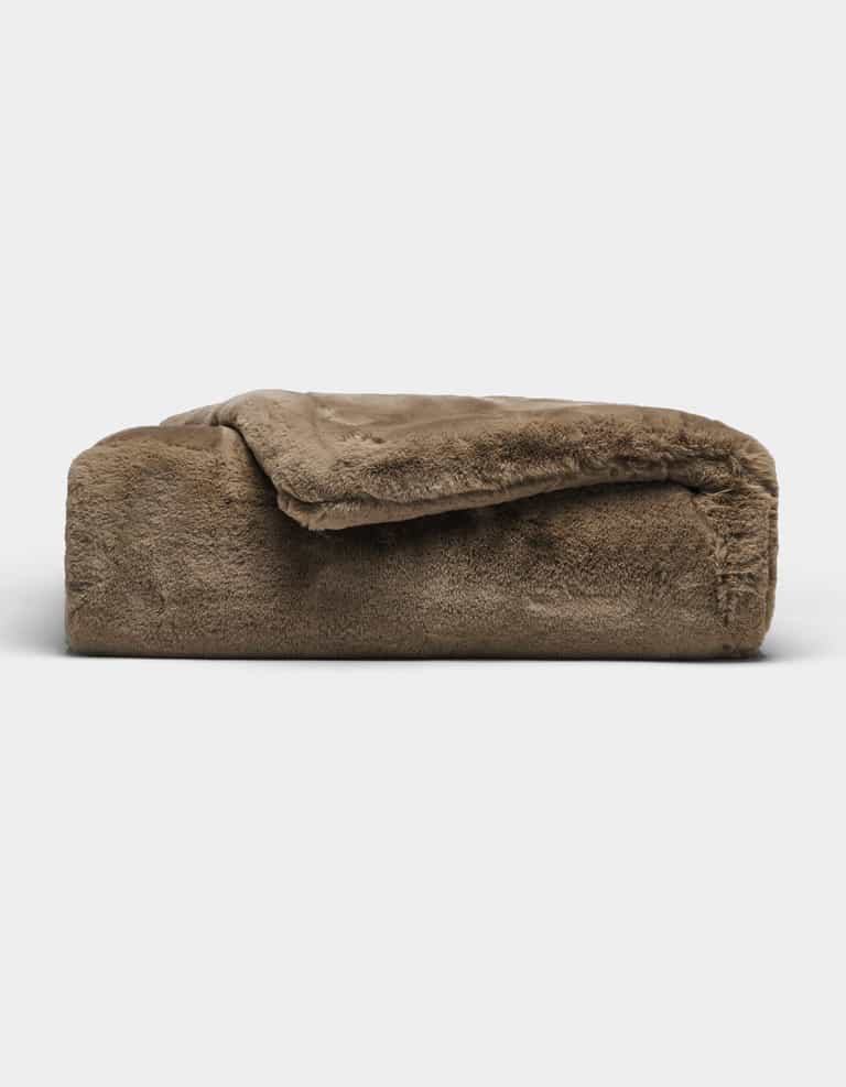 The Cozy Earth Cuddle Blanket, featuring a plush brown fabric and soft, fuzzy texture, is shown folded against a plain white background.|Color:Walnut